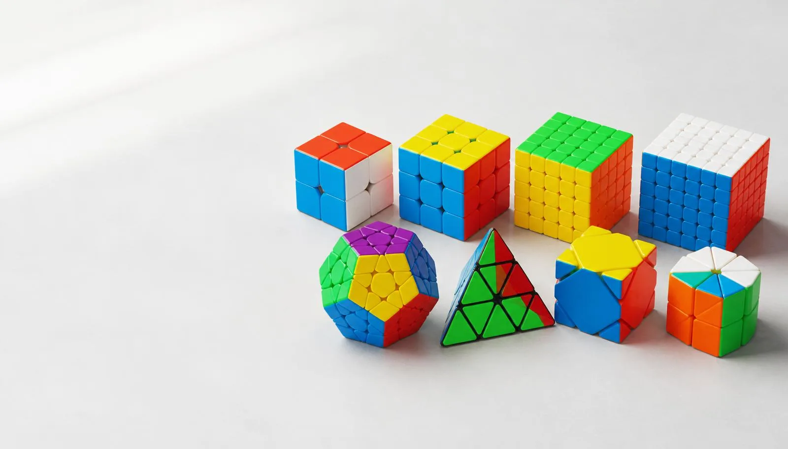 Speedcube, megaminx and pyraminx puzzles on a light surface